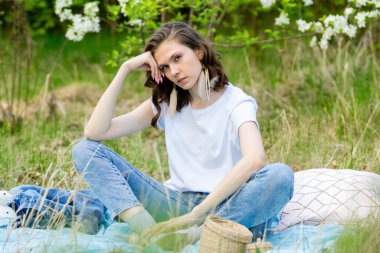 Bahar yürüyüşü. Bir kız çiçek açan bir elma bahçesinde yürüyor.