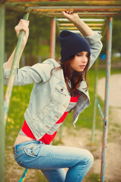 Portrait of a beautiful girl sitting in hat at the park outdoor — Stock Photo, Image