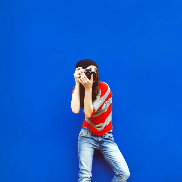 Portret pięknej dziewczyny z kamerą na czerwone ściany i blu — Zdjęcie stockowe