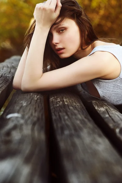 Portrait of beautiful girl lying on a jetty with a languid glance — Stock Photo, Image