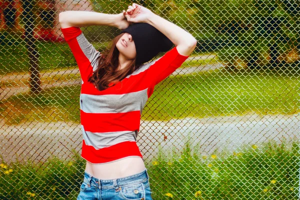 Ritratto di una bella hipster in cappello e giacca a righe — Foto Stock