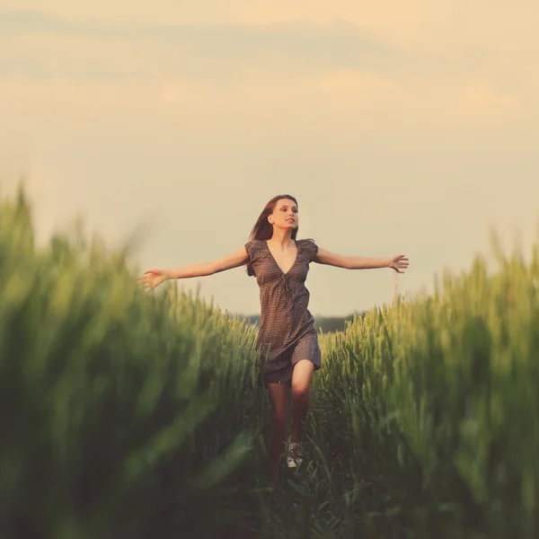 Mulher feliz correndo no campo verde — Fotografia de Stock