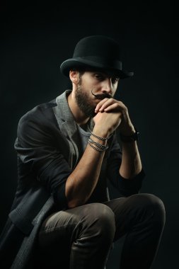 Melon şapkalı bir düşünceli sakallı adam ellerini sıktı