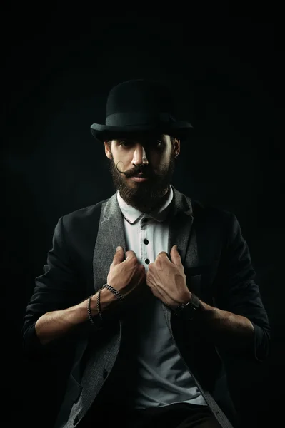 The bearded man in a bowler hat holding his lapels — Stock Photo, Image