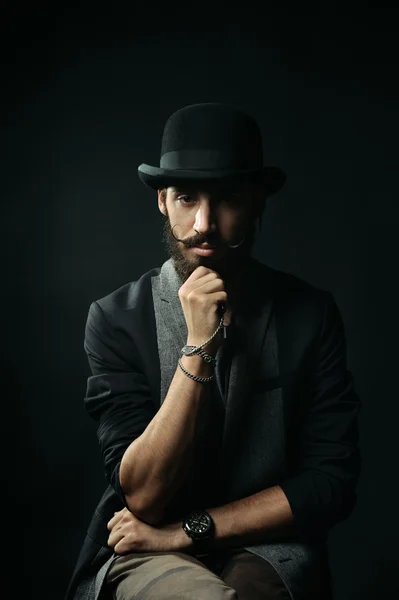 The bearded man in a bowler hat touching his beard — Stock Photo, Image