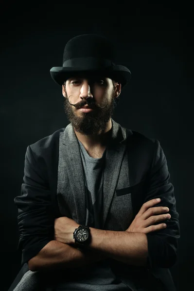 The bearded man in a bowler hat folded his arms across his chest — Stock Photo, Image