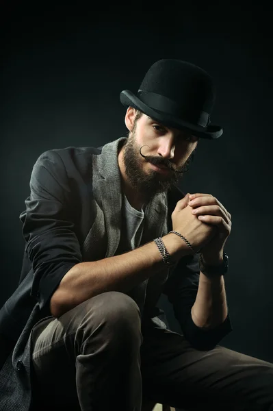 The bearded man in a bowler hat clenched his hands into the lock — Stock Photo, Image