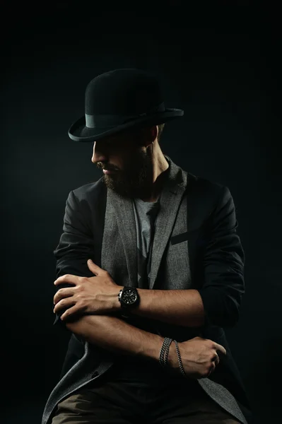 The bearded man in bowler hat rolls up sleeves of his jacket — Stock Photo, Image