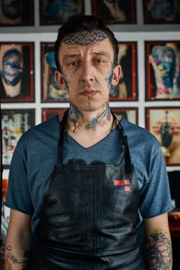 Deri önlük dövmeli adam