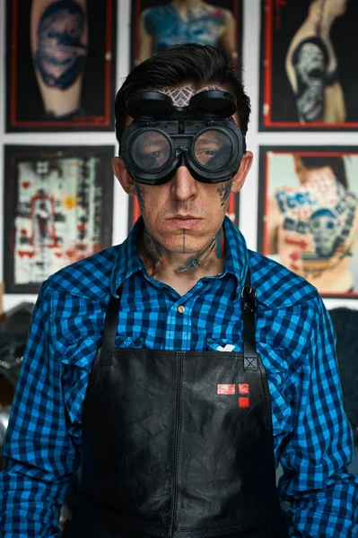 Tattoo artist in welder glasses in studio — Stock Photo, Image