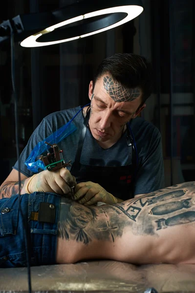 Мастер татуировки за работой в студии — стоковое фото