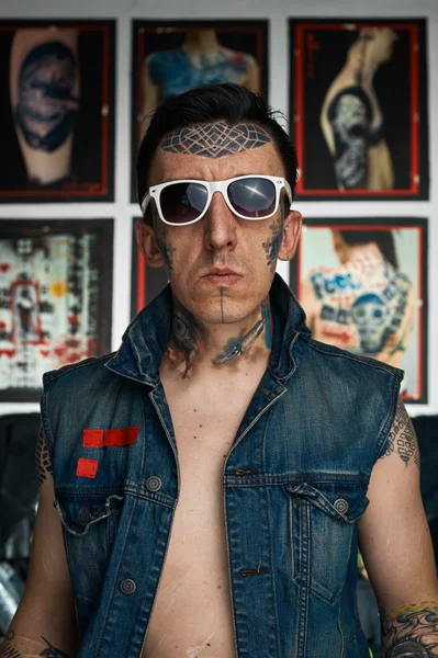 Homem tatuado em colete de ganga e óculos de sol — Fotografia de Stock
