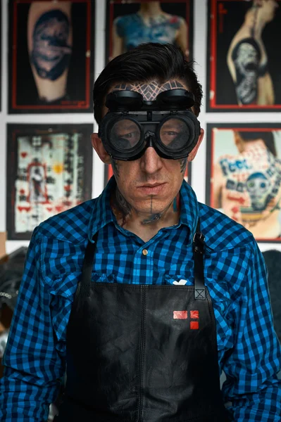 Tattoo kunstenaar in lasser glimlachend bril in studio — Stockfoto