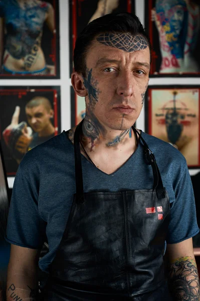 Tattooist in black leather apron in studio — Stock Photo, Image