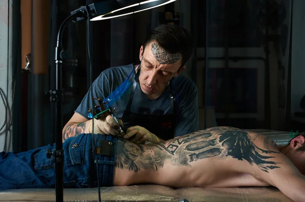 Τατουάζ καλλιτέχνης δημιουργεί ένα σχέδιο τατουάζ — Φωτογραφία Αρχείου