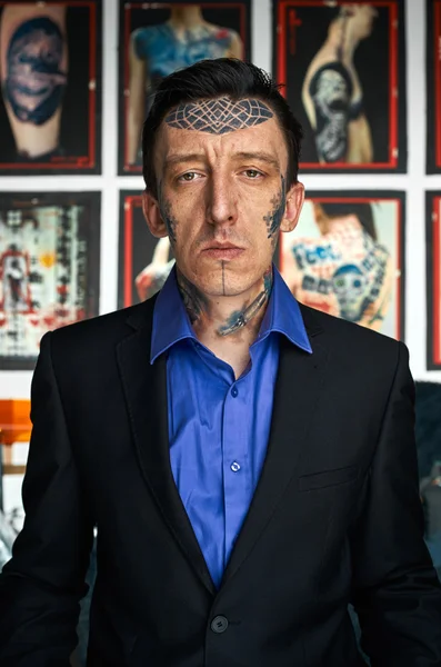 Mestre de tatuagem em jaqueta preta e camisa azul em estúdio — Fotografia de Stock