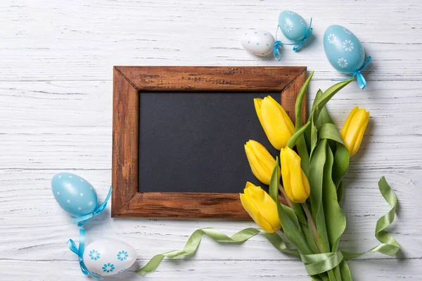 Ostereier Kreidetafel Und Gelber Tulpenstrauß Auf Holzgrund Draufsicht — Stockfoto