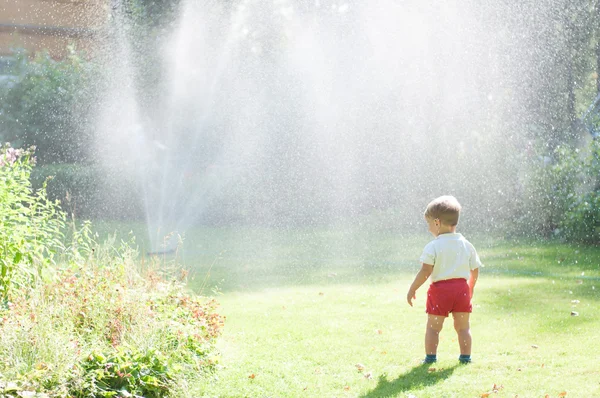Dziecko patrzy na fontannę — Zdjęcie stockowe
