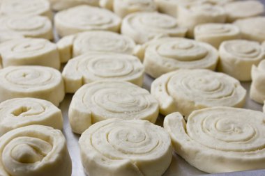 Bir fırın tepsisine maya hamurdan Spiral tarçın çörekler. Ev yapımı pişirme.