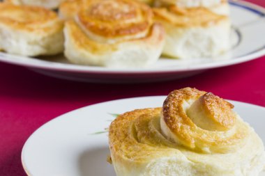 Kırmızı arka plan tarihinde spiral tarçınlı Fransız çörek. Homemade pişirme.
