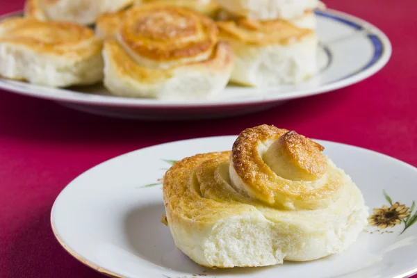 Spirale cannella panini francesi su sfondo rosso. Cottura fatta in casa . — Foto Stock