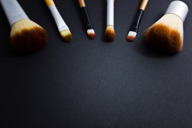 Siyah bir zemin üzerine profesyonel makyaj için fırçalar bir dizi.