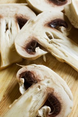 Beyaz ham champignon closeup yalan ahşap bir masa üzerine.