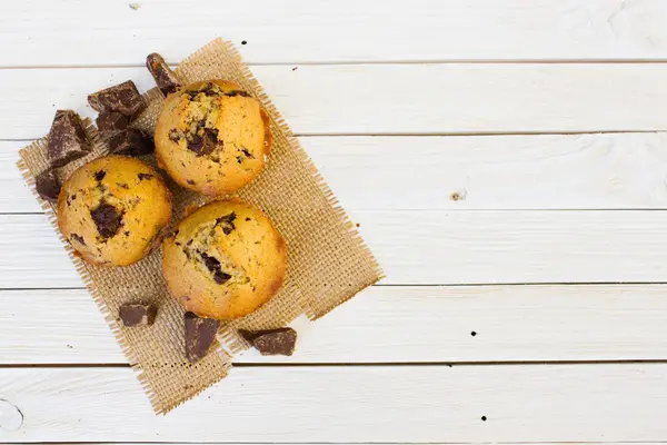 Magdalenas de chocolate sobre una mesa de madera blanca . — Foto de Stock