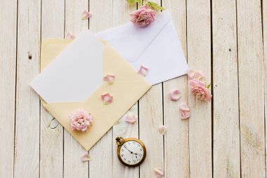 İçinde kart olan iki zarf, eski cep saati ve bir gül