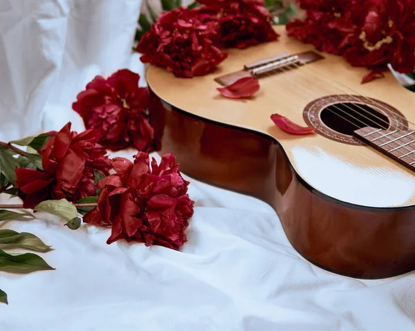 Acoustic Wooden Guitar Lies White Sheet Surrounded Red Peonies Cover Stock Picture