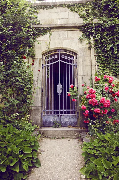 Jardin avec une allée menant à la porte forgée vintage — Photo