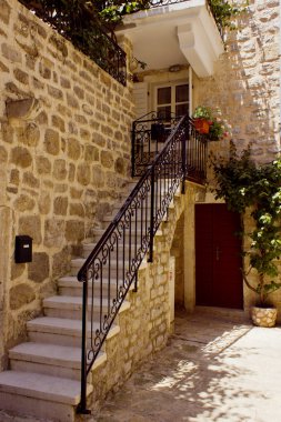 Küçük balkon ve eski şehrin üzerine çiçeklerle beyaz tuğla ev