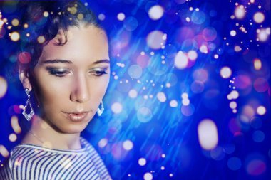 Yeni yıl partisi bir yılbaşı makyaj ile genç güzel kız. Mavi ışıklar bir kız portresi.