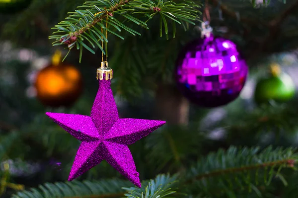 Violette und grüne Glaskugeln am Weihnachtsbaum. Neujahrs- und Weihnachtsgrußkarte. — Stockfoto