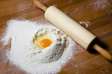 Malzemeler hamur ahşap bir masa üzerinde yemek pişirmek için. Un, yumurta ve bir oklava.