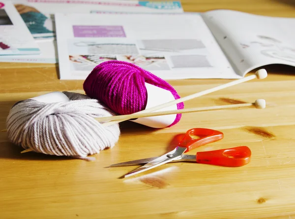 Accessoires de tricot sur une table en bois. Boules de laine et aiguilles à tricoter en bois sur la table . — Photo