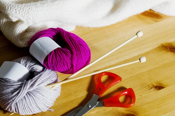 Strickzubehör auf einem Holztisch. Wollknäuel und Stricknadeln aus Holz auf dem Tisch. — Stockfoto