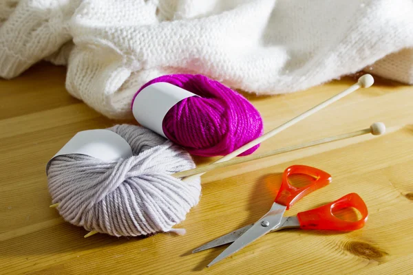 Accessoires de tricot sur une table en bois. Boules de laine et aiguilles à tricoter en bois sur la table . — Photo