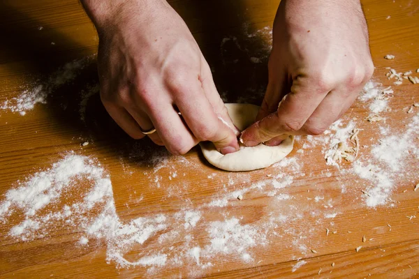 Мужские руки месят тесто на деревянном столе. Шеф-повар готовит тесто для итальянской кухни. . — стоковое фото
