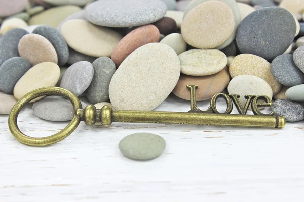 Antique Key to Love on a beach stone background — Stock Photo, Image