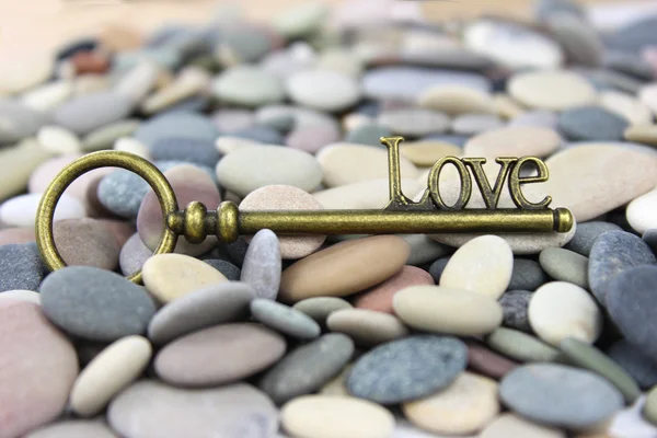 Chave para o amor em uma pedra de praia ou fundo de seixo . — Fotografia de Stock