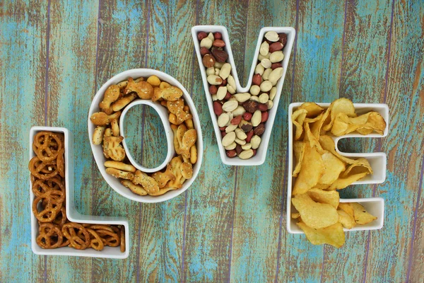 Snacks in Love em forma de tigelas de letras em fundo rústico — Fotografia de Stock