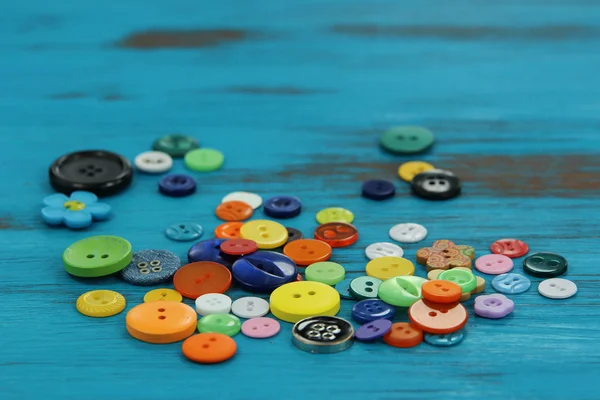 Bright colored buttons on a rustic blue wooden background — Stock Photo, Image