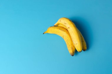 Mavi arka planda izole edilmiş sarı muz grubu, boş alan.