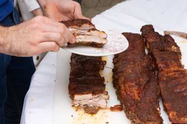 Baharatlı sosla marine edilmiş pirzola kesen kişi..