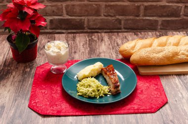 Kızarmış pirzola, barbekü sosuyla marine edilmiş patates püresi, spagetti ve ekmek. Tahta masada servis edilen bir tabak yemek.