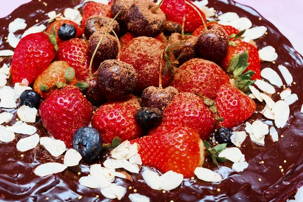 木製のテーブルの上に赤い果実で飾られたブラウニーケーキ — ストック写真