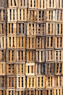 Yığılmış ahşap sandıklar, desenli ve kırsal bir zemin oluşturuyor..