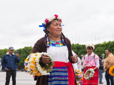 Mexico City, Meksika. 11 Ekim 2025: Geleneksel elbiseli ve çiçekli yaşlı kadınlar Guadalupe Meryem Ana 'nın Bazilikası' nın önünde dans ediyorlar..