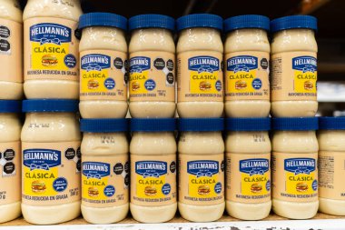Colima, Colima, Mexico. December 7, 2025: A close up of several Hellmann's Clasica mayonnaise jars stacked on a shelf in a supermarket.